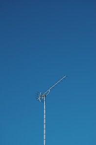 black electric post under blue sky