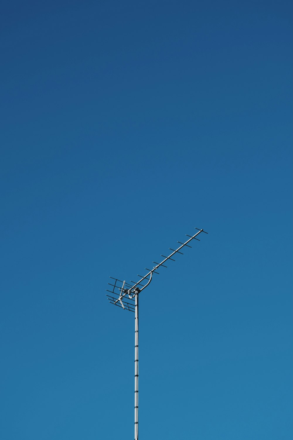 black electric post under blue sky