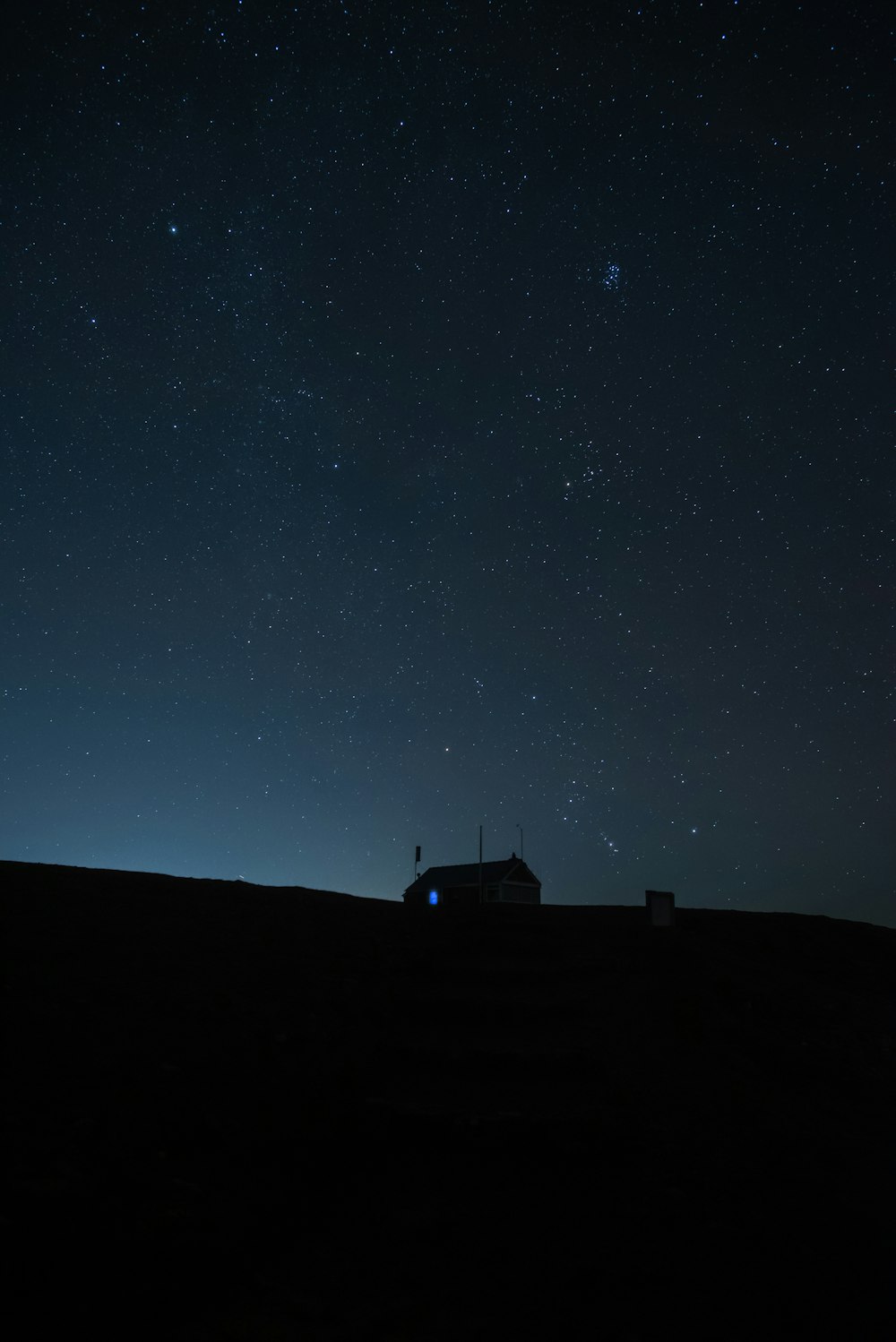 silhouette of house under starry night