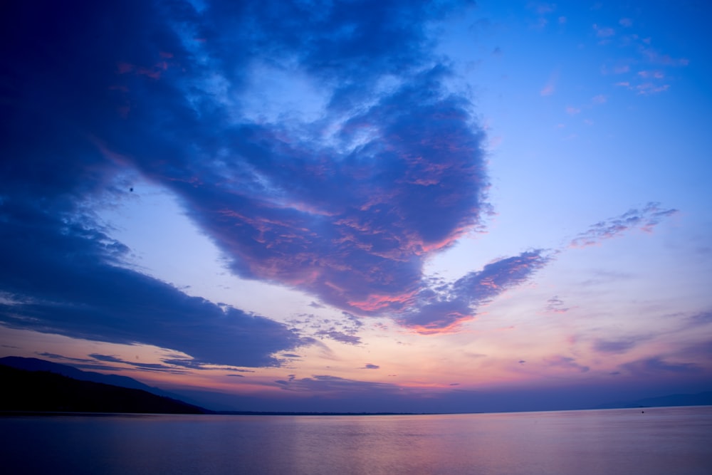 body of water under blue sky and white clouds during daytime