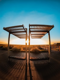 Golden-hour photo of a teak pergola casting warm shadows over a Caribbean villa terrace.