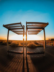 A sleek aluminum motorized louvered pergola casting adjustable shade over a modern terrace at golden hour.