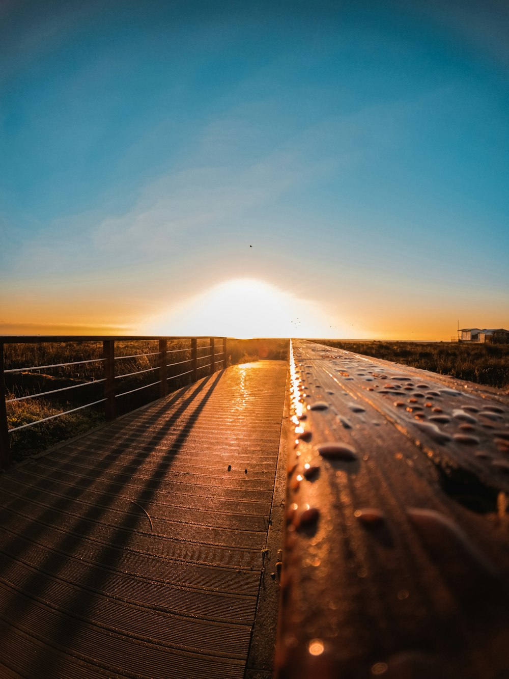 brown wooden bridge over the sea during sunset