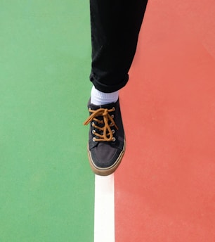 person in black pants wearing black and white nike sneakers