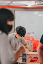 man in gray crew neck t-shirt sitting beside woman in orange t-shirt