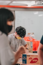 man in gray crew neck t-shirt sitting beside woman in orange t-shirt