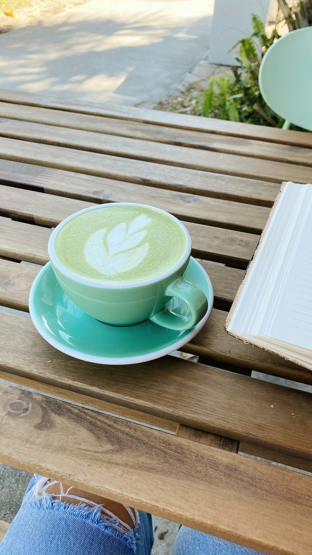 green ceramic mug with saucer on brown wooden table