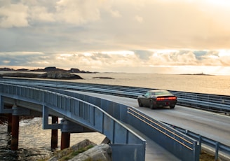 black suv on gray concrete bridge under gray cloudy sky during daytime