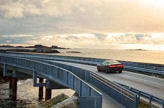 black suv on gray concrete bridge under gray cloudy sky during daytime