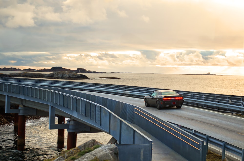 black suv on gray concrete bridge under gray cloudy sky during daytime