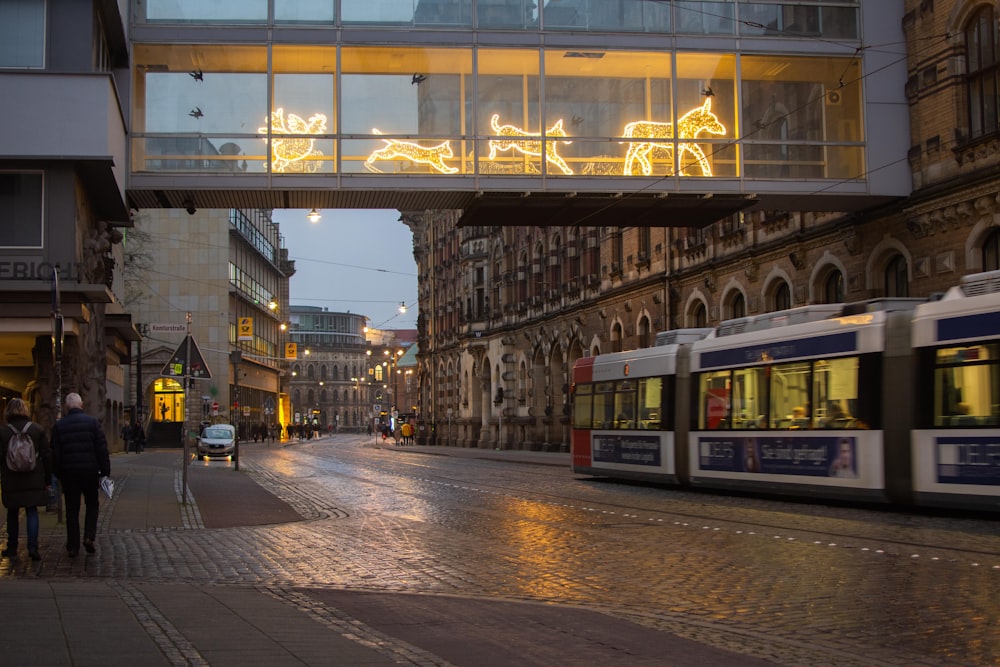 people walking on sidewalk near train station during night time