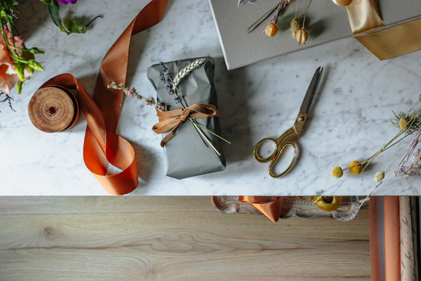 A beautifully wrapped gift card resting on a soft spa towel with delicate rose petals scattered around.