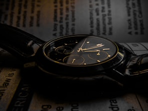 Elegant wristwatch with leather strap resting on an open book.