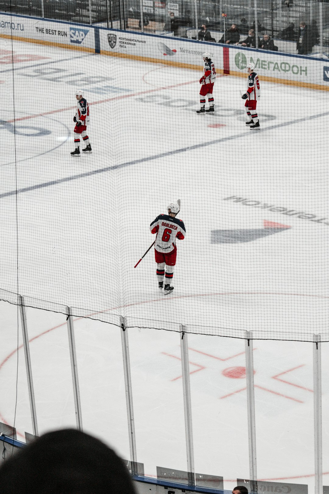 man in red and white ice hockey jersey shirt and black pants playing hockey