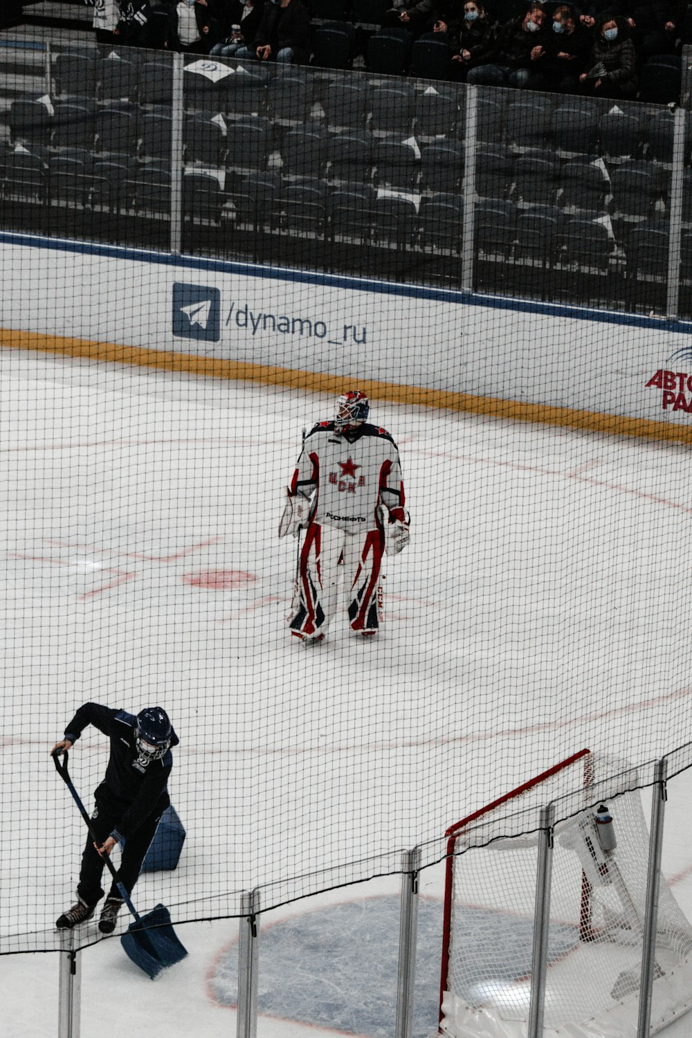 man in black jacket and black pants playing ice hockey