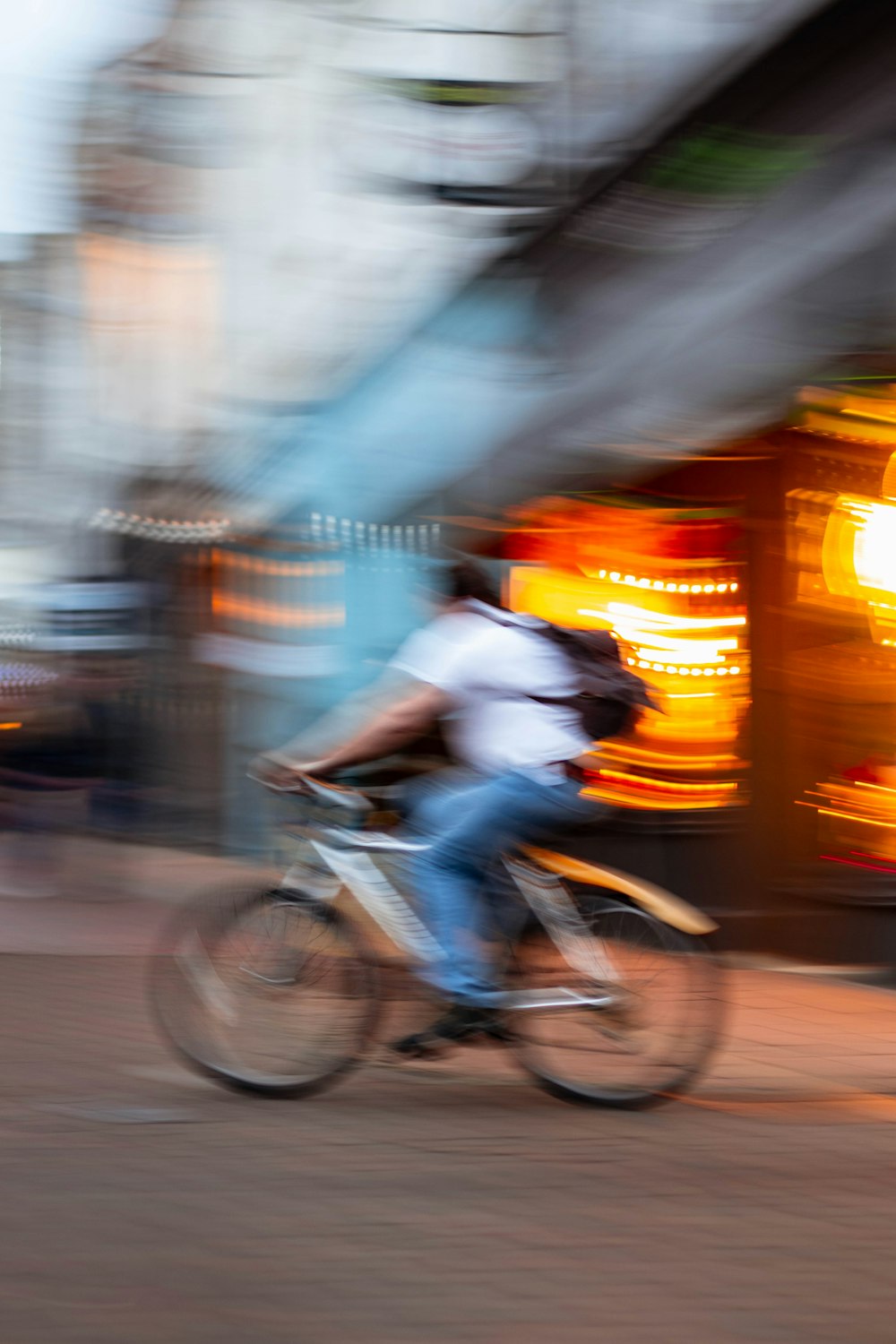 man in white shirt riding bicycle on road during daytime