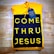 A folded yellow hoodie with a design reading 'COME THRU JESUS' in large, bold yellow letters on a black background. A blue tag attached to the hoodie reads 'FRESH HOPE APPAREL'. The hoodie is placed on a wooden surface.