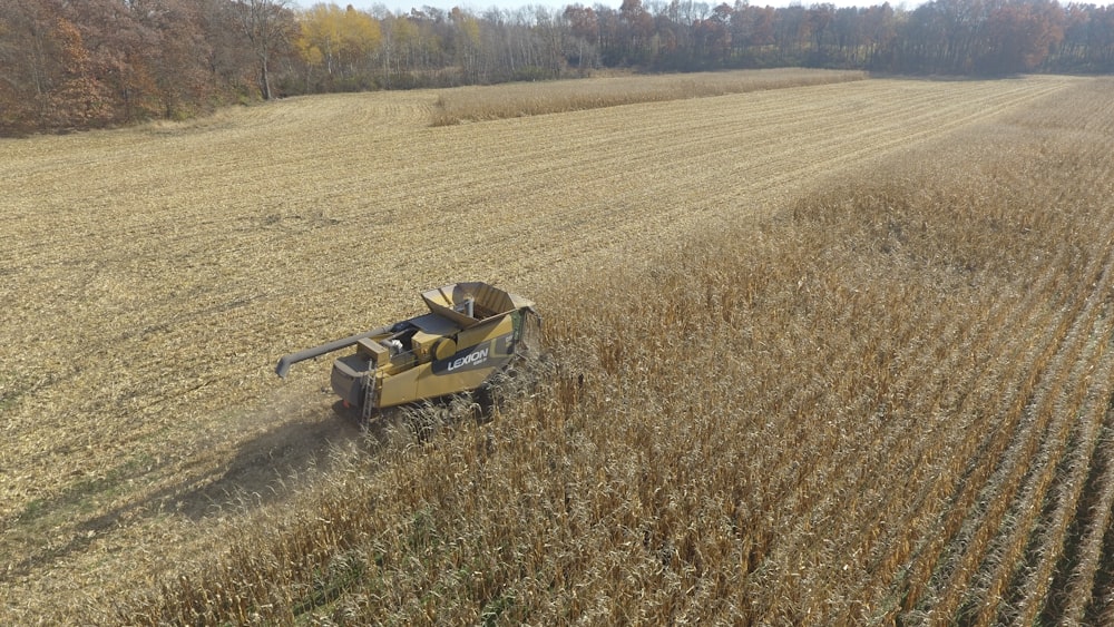 black and yellow ride on lawn mower on brown field during daytime