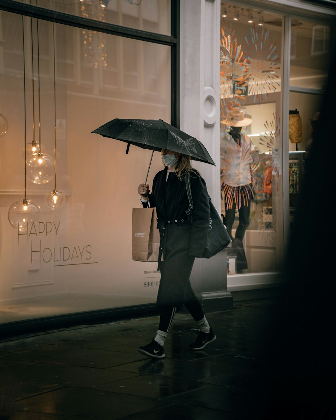 woman in black coat holding umbrella