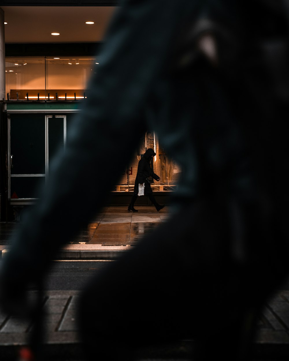 silhouette of people walking on sidewalk during night time