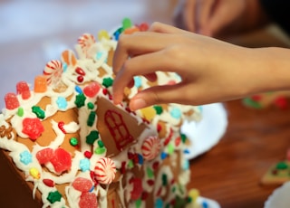 person holding white and brown chocolate cake