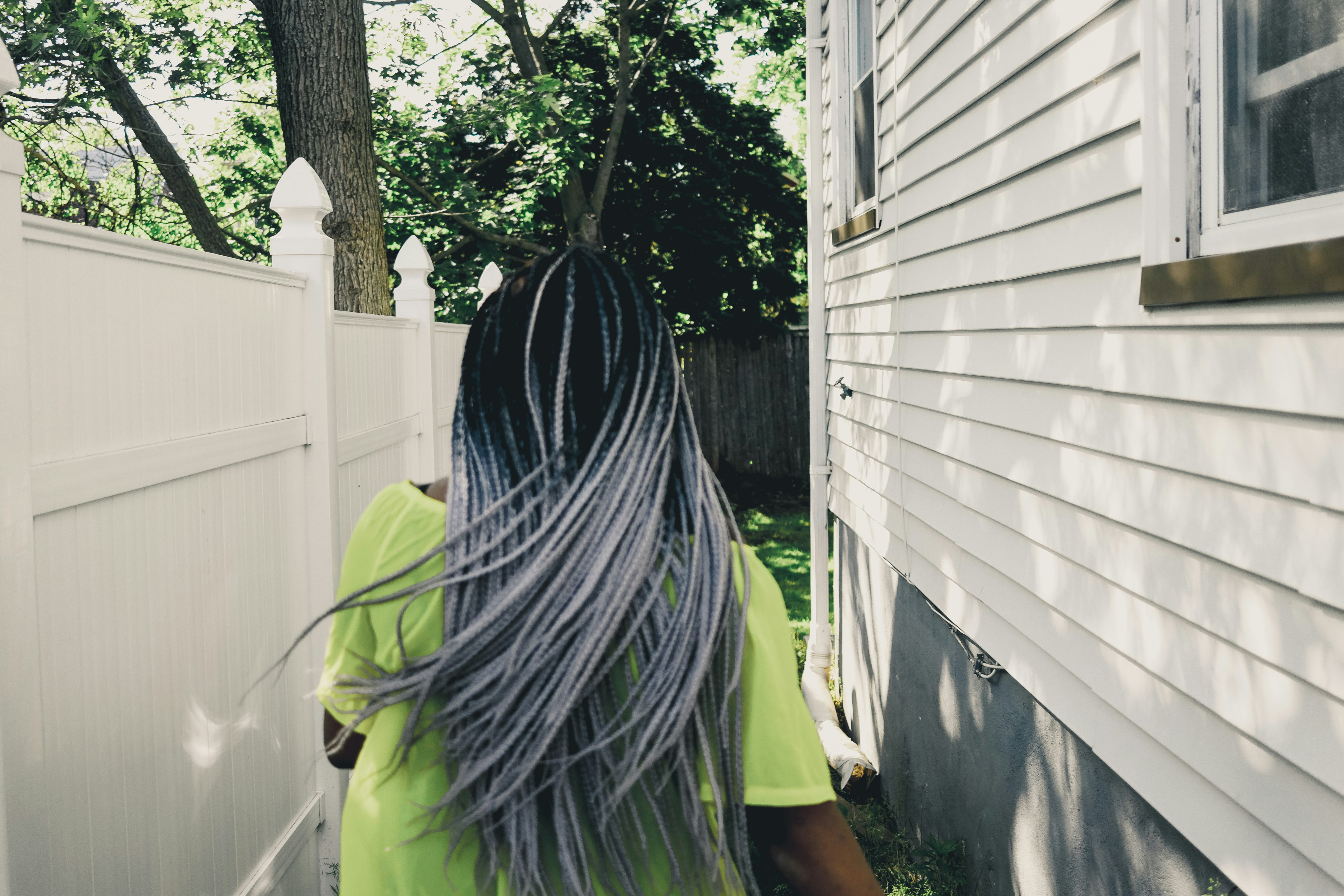 person in green shirt standing near green tree during daytime