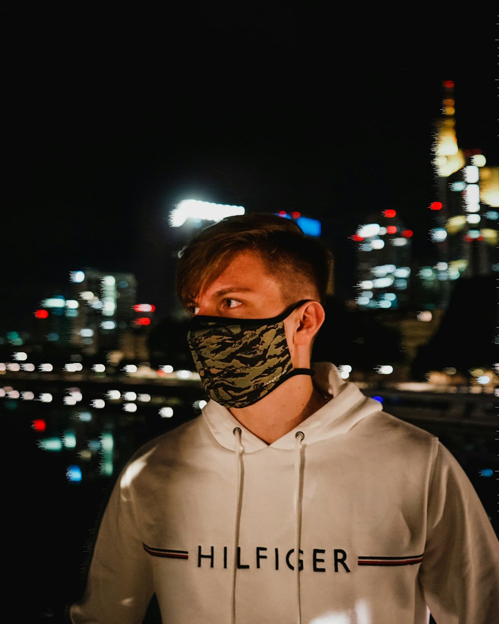 man in white zip up hoodie wearing black and white mask