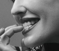 grayscale photo of woman with hand on her chin