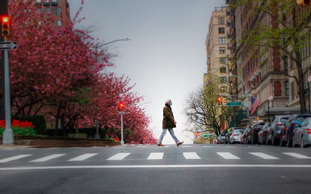 woman in brown coat standing on the road during daytime