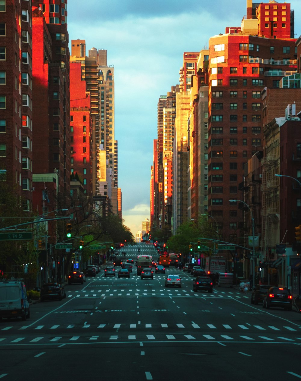 cars on road in between high rise buildings during daytime