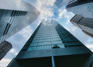 low angle photography of high rise building under white clouds during daytime