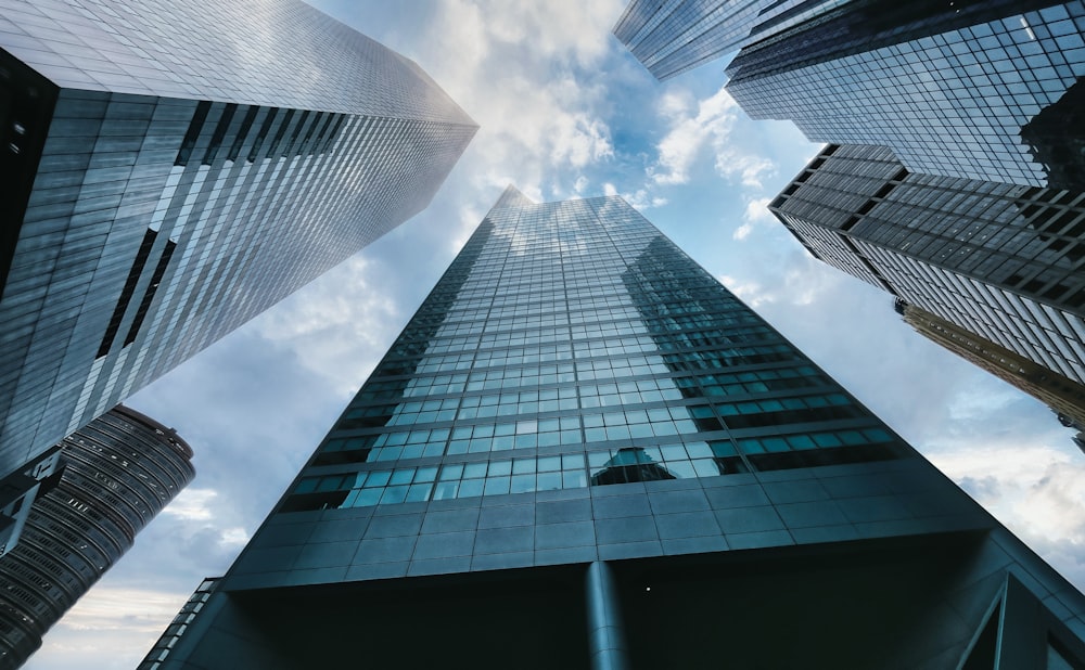 low angle photography of high rise building under white clouds during daytime