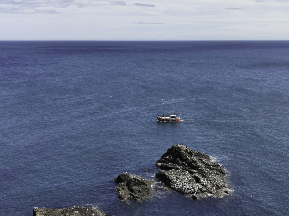 red and white boat on blue sea during daytime