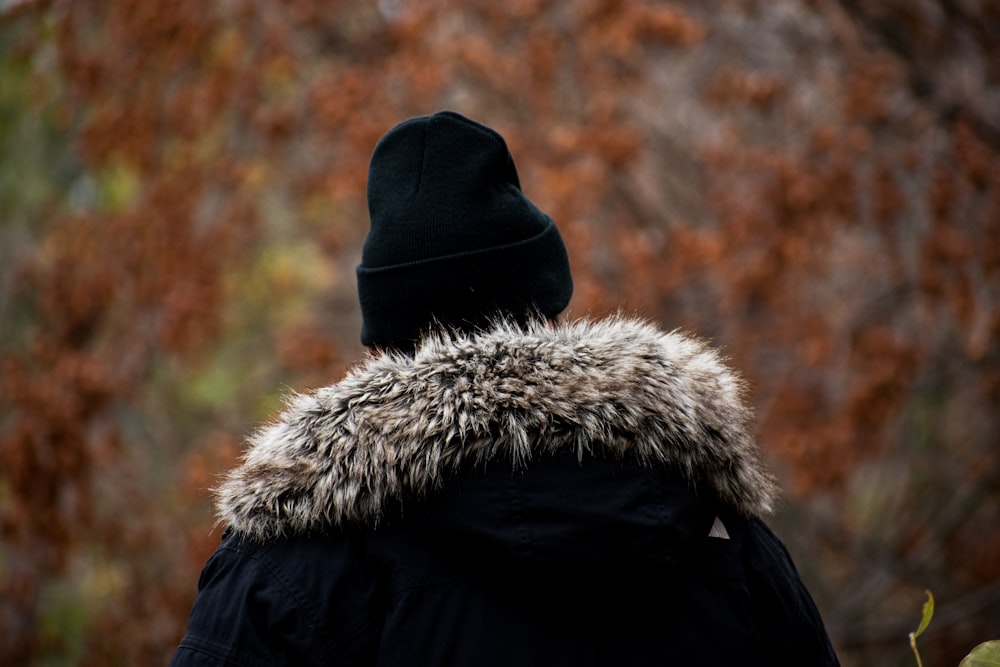 person in black and white fur coat and black knit cap