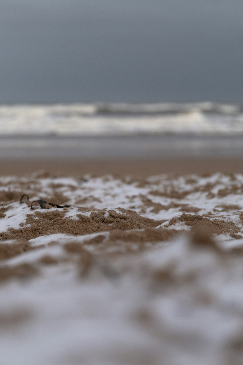 brown sand near body of water during daytime