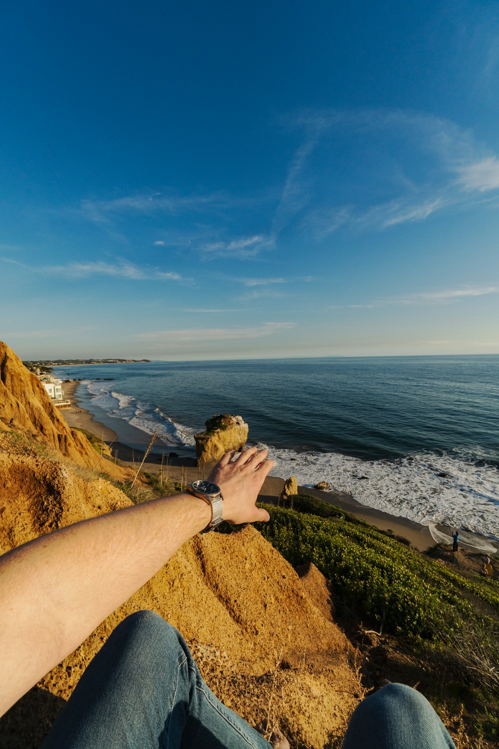 woman in black shirt standing on brown rock formation near body of water during daytime