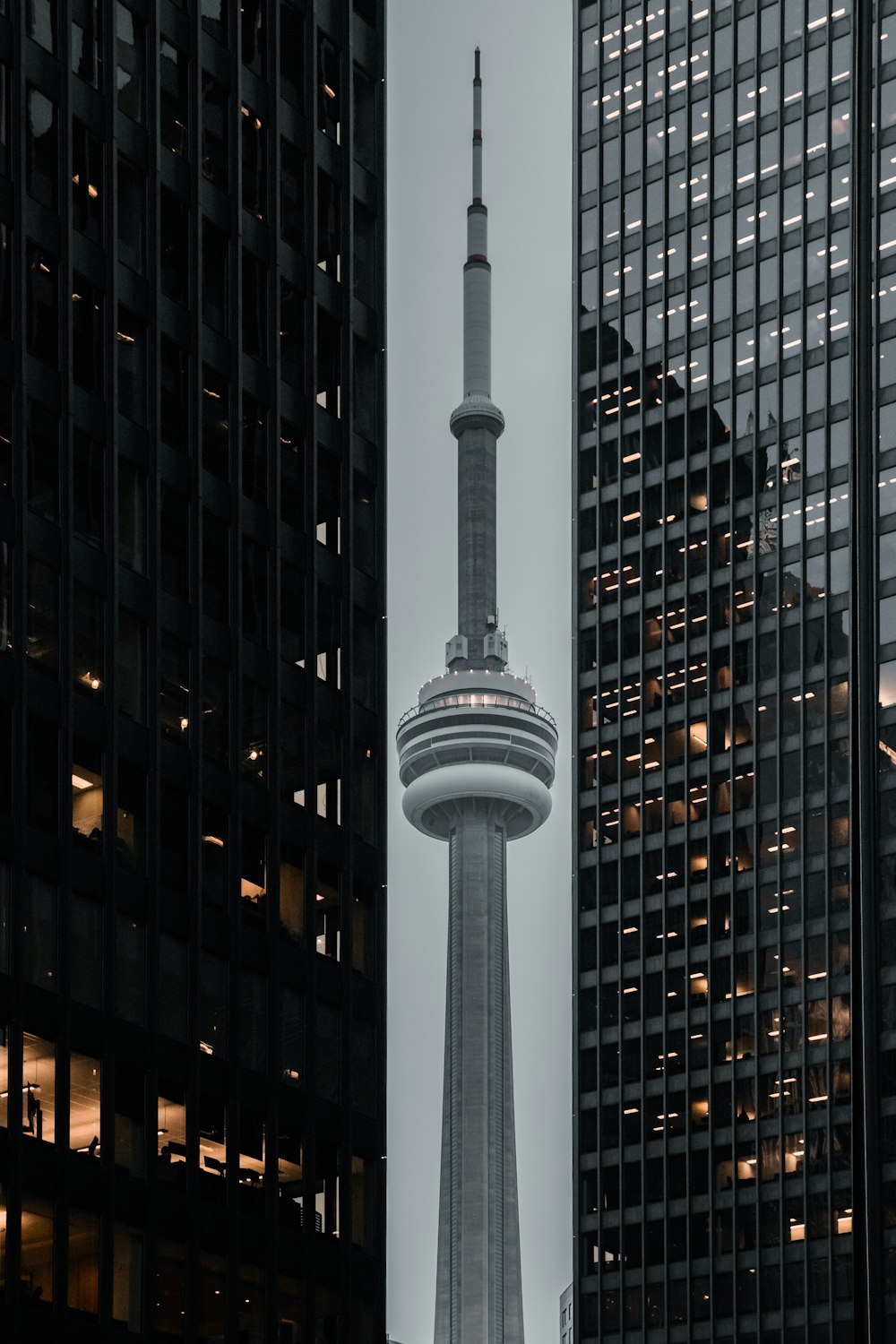 낮 동안 고층 건물 근처의 흰색 콘크리트 타워