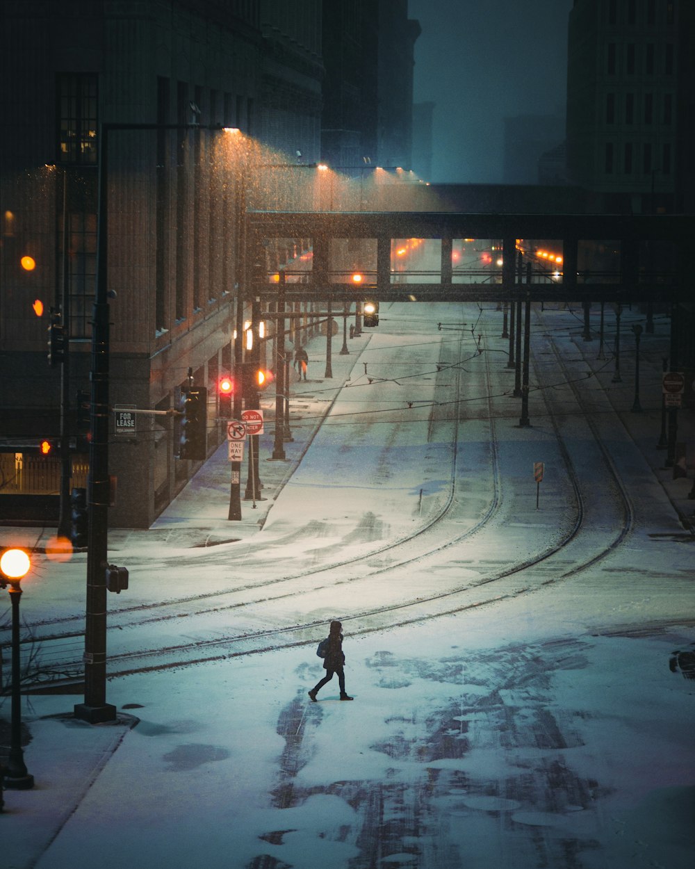 hombre con chaqueta negra caminando por la calle durante la noche