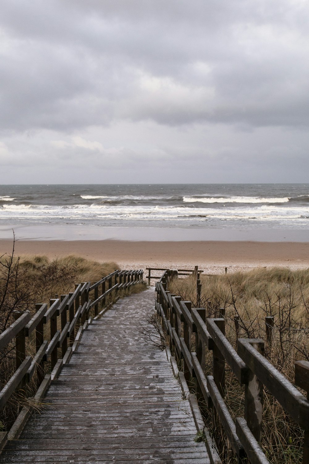 Valla de madera marrón en la orilla del mar durante el día