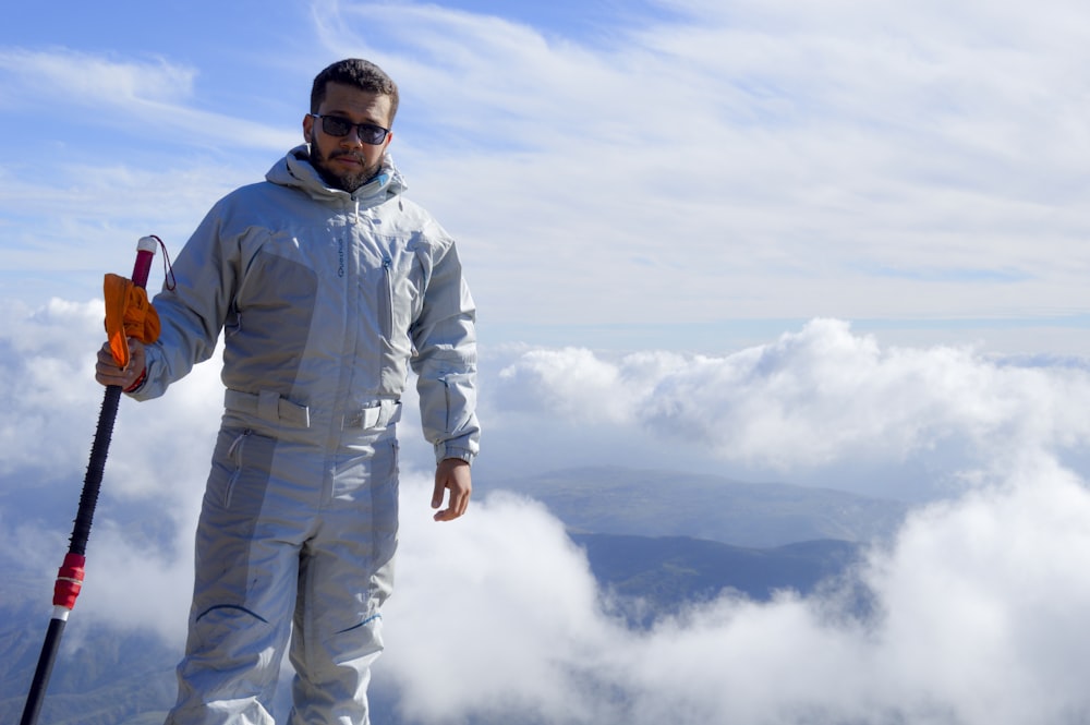 Hombre en chaqueta azul de pie sobre nubes blancas durante el día