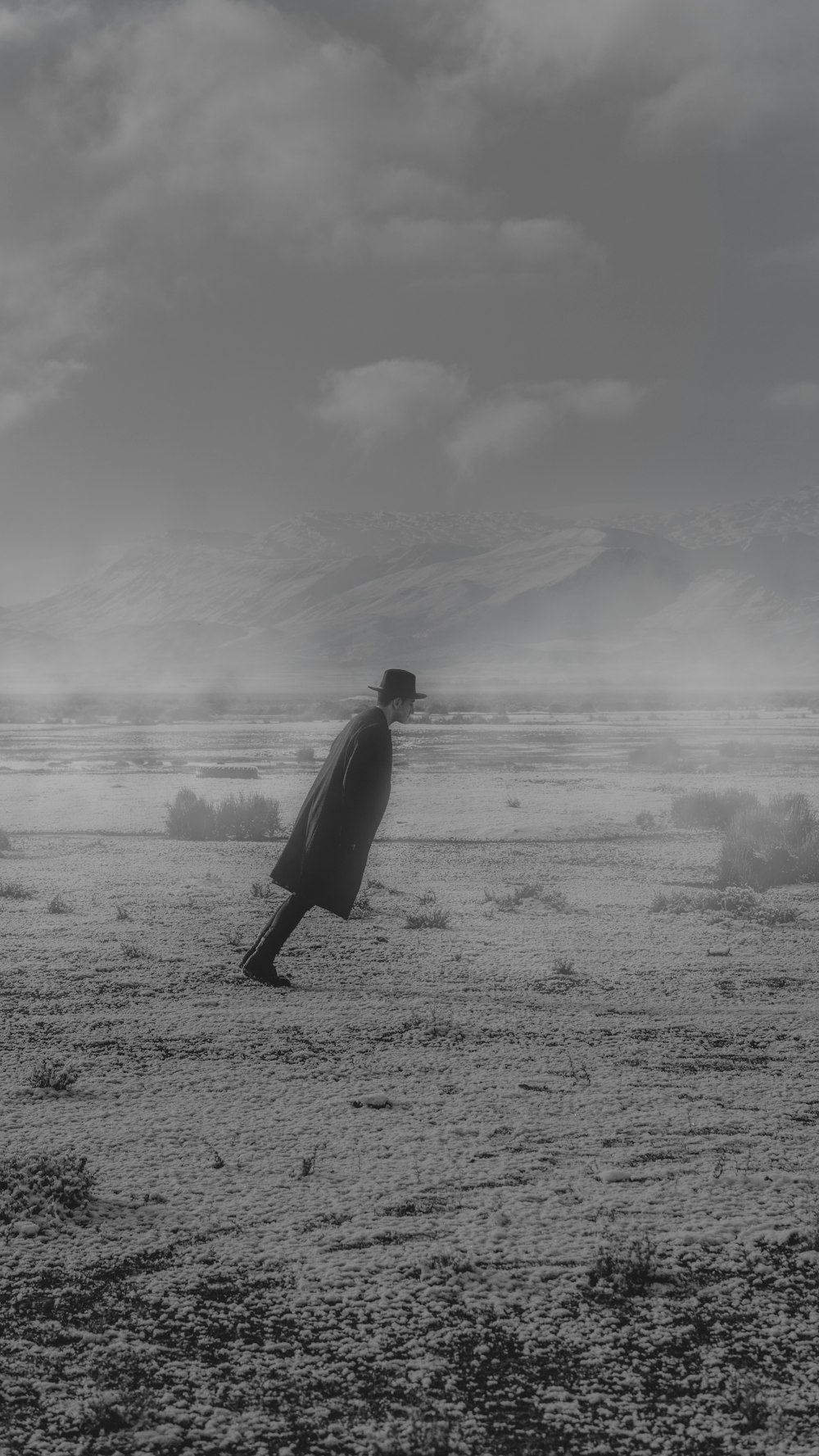 man in black long sleeve shirt walking on seashore