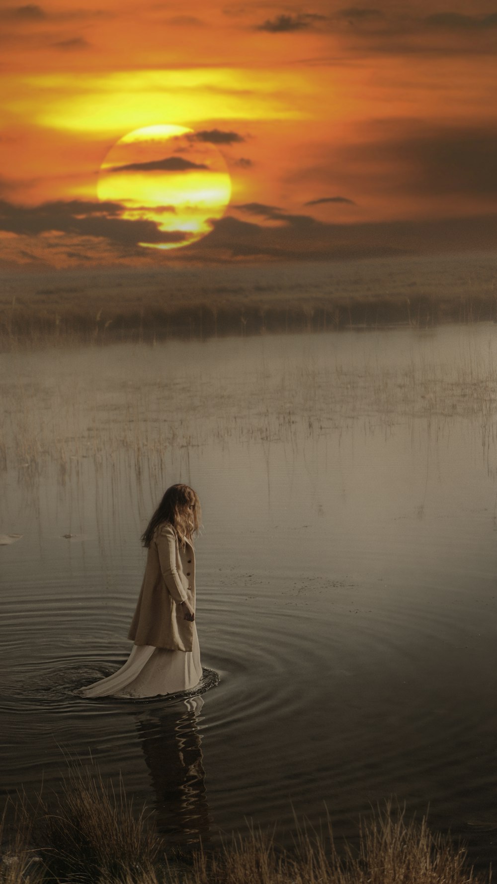 woman in white dress standing on water during sunset