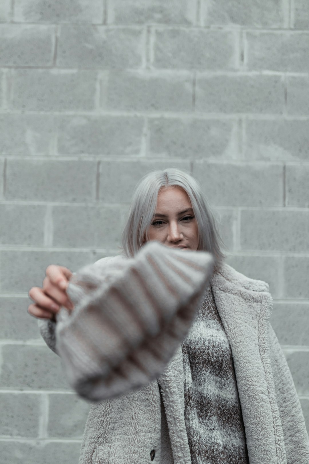 woman in gray sweater holding her hair