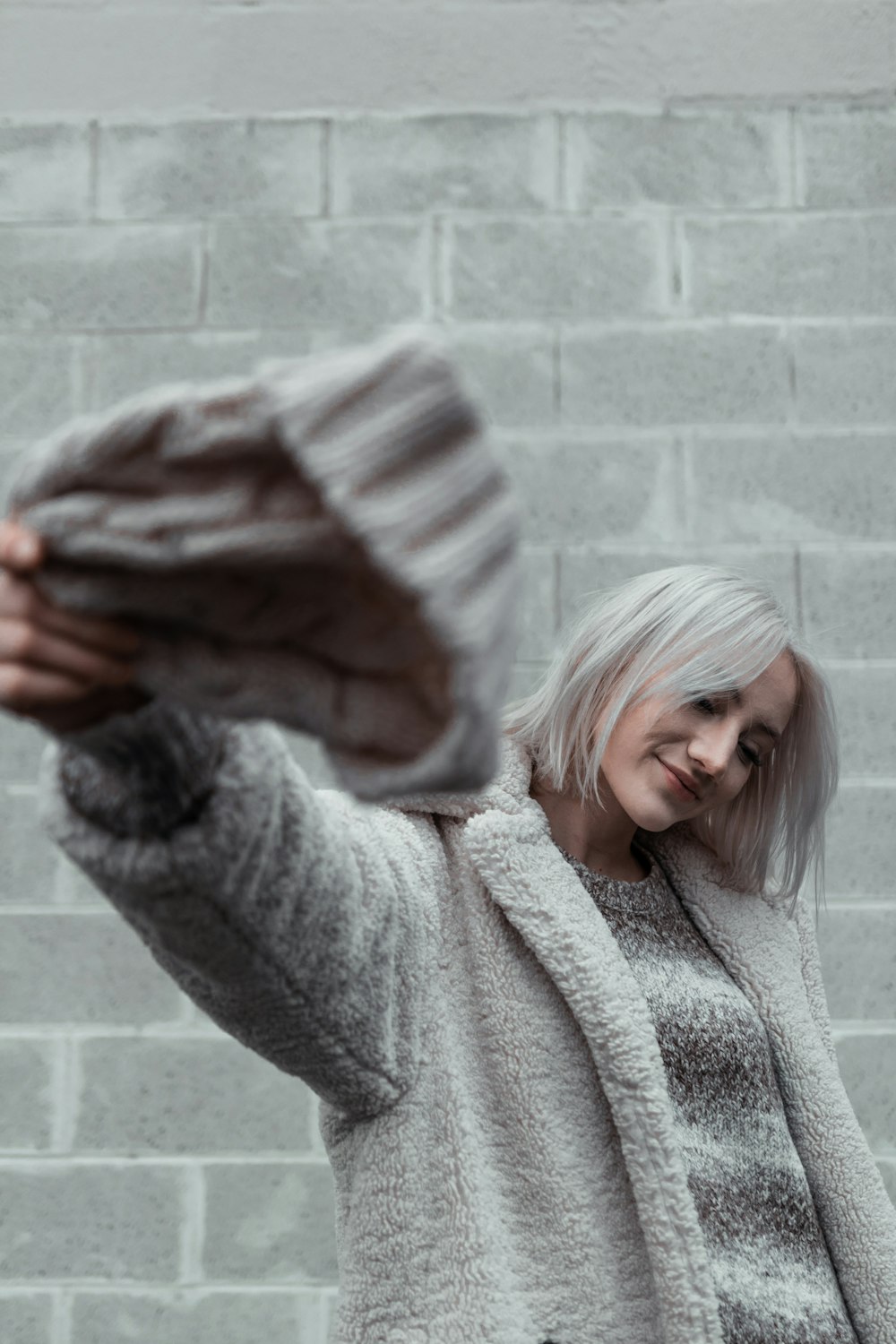woman in gray sweater covering face with hands