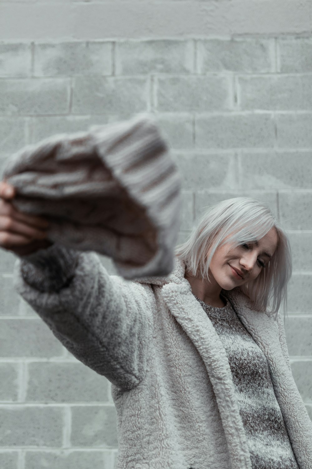 Femme en pull gris couvrant le visage avec les mains