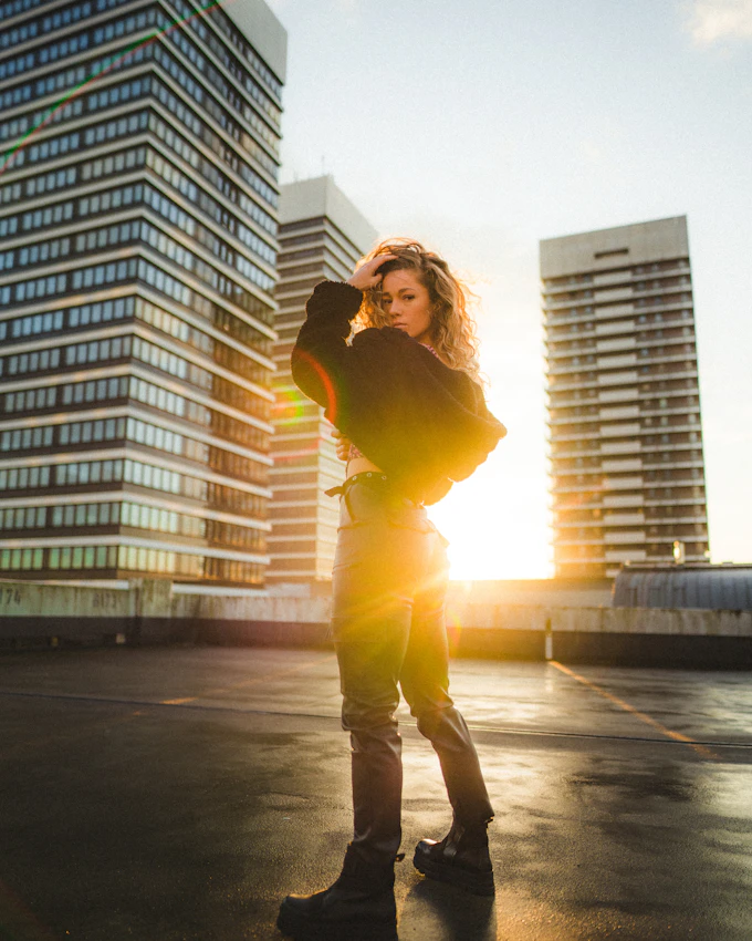 woman in yellow shirt standing confidently in a city