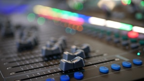 Sound mixing console with colorful lights and sliders in a studio