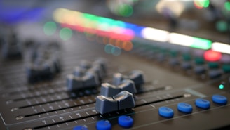 Sound mixing console with colorful lights and sliders in a studio
