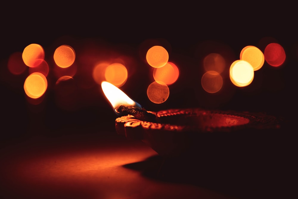 lighted candle on black metal holder