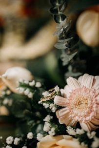 A close-up of wedding rings on a bouquet.